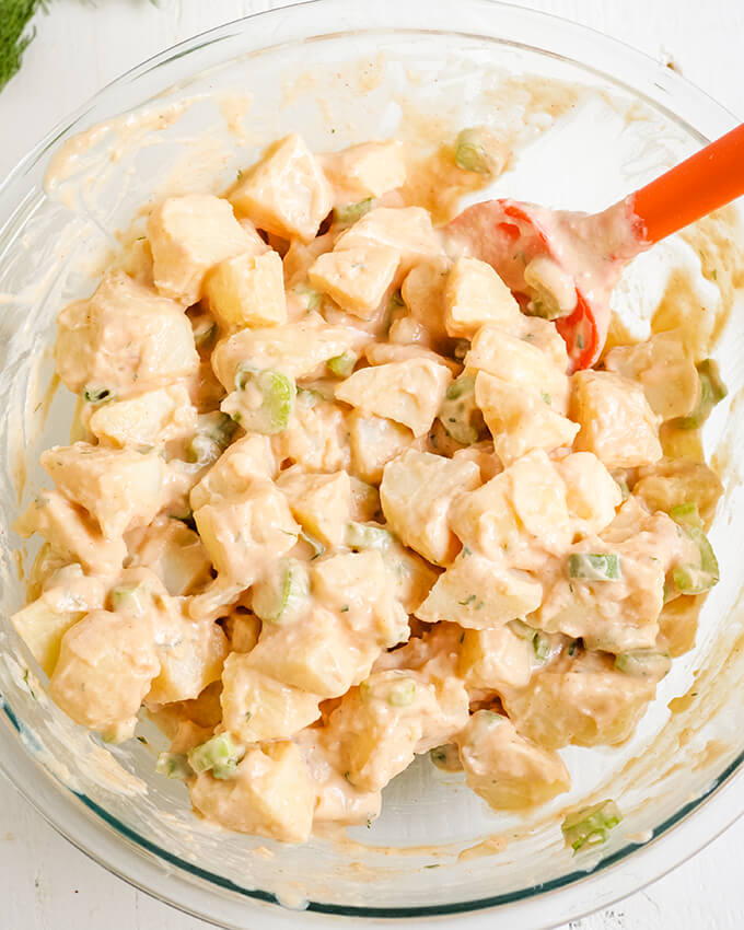 Potato salad in a bowl with oil-free mayo and celery.