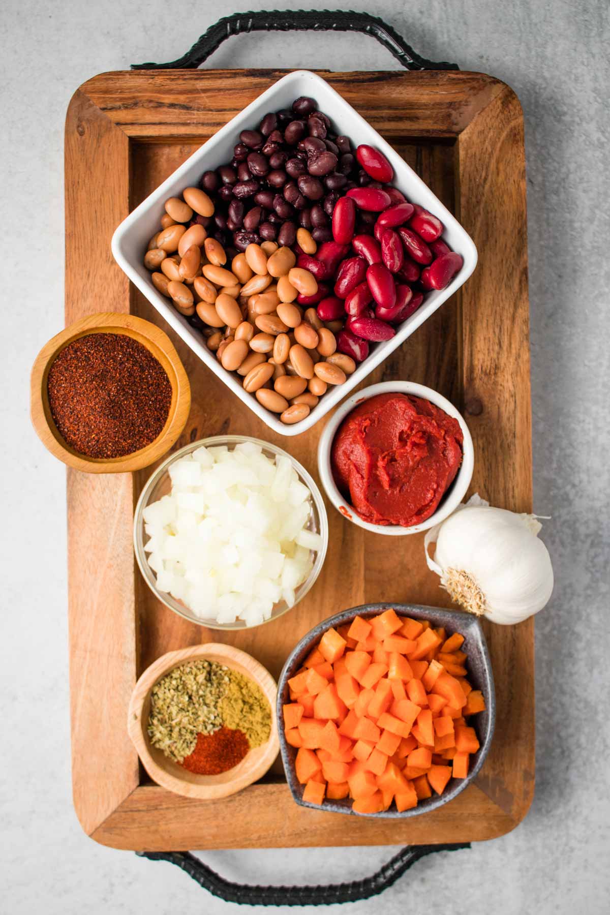 Ingredients for chili on a tray, including beans, carrots, and seasoning.