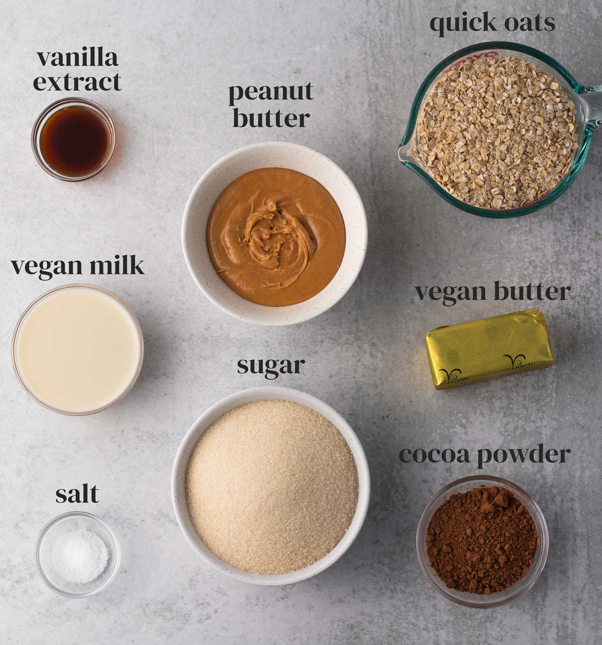 ingredients for no-bake vegan cookies with oats, peanut butter, vanilla, sugar, chocolate, and salt