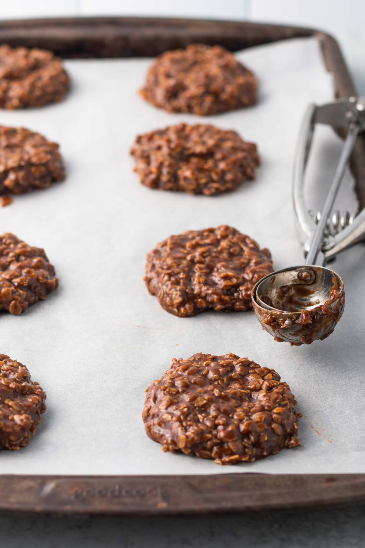 scooping no-bake cookie dough onto a parchment-lined baking sheet